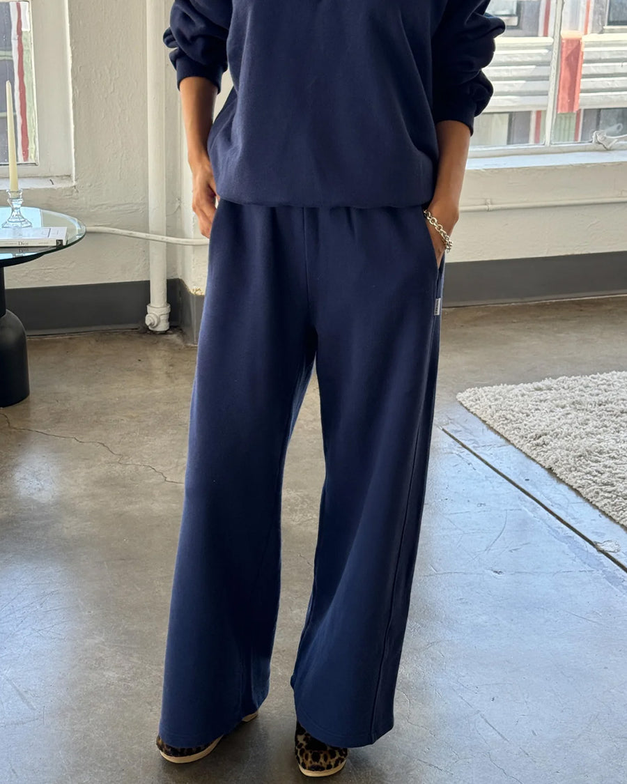 model wearing relaxed navy sweatpants with side pockets