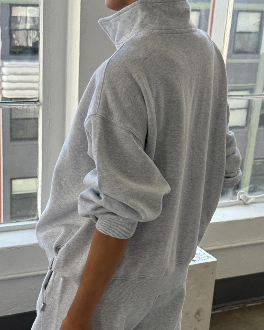 back view of model wearing relaxed fit heather grey french terry quarter zip sweatshirt