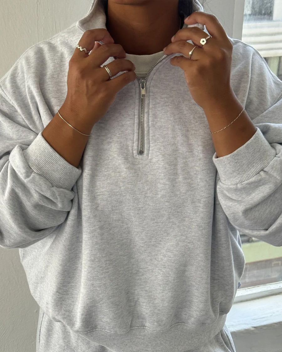 up close of model wearing relaxed fit heather grey french terry quarter zip sweatshirt