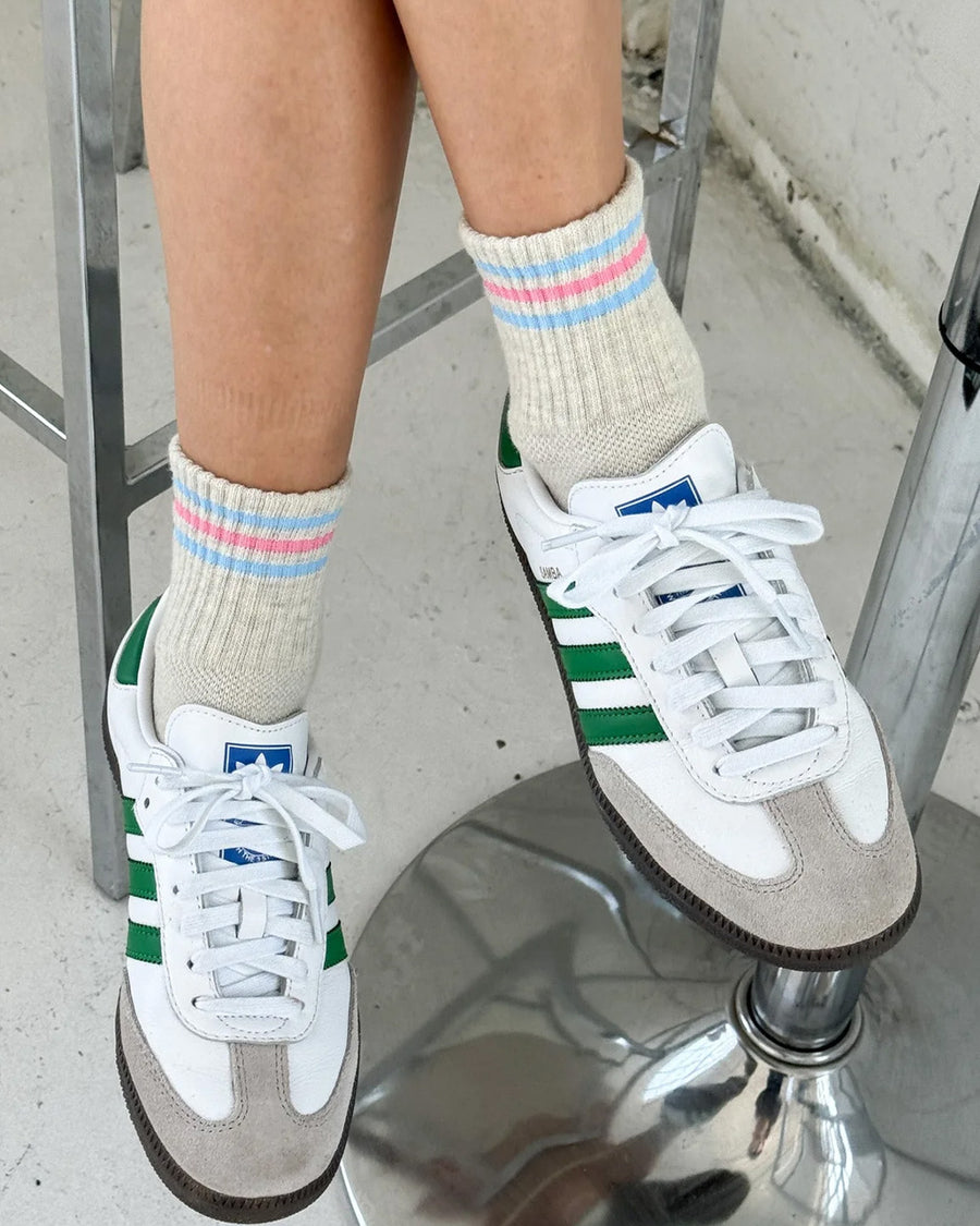 model wearing heather grey socks with light blue and light pink stripes on the top