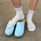 up close of model wearing heather grey socks with light blue and light pink stripes on the top