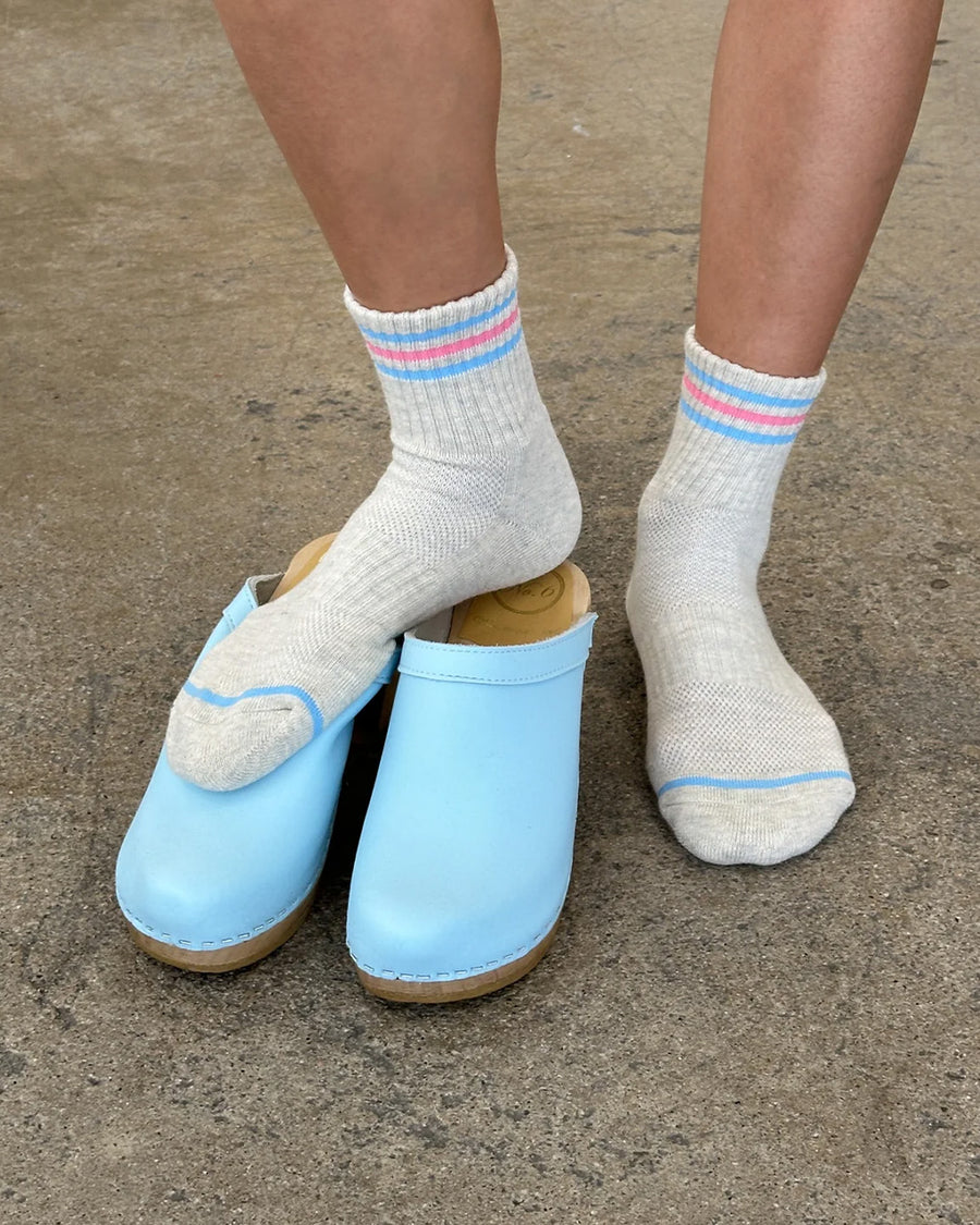 up close of model wearing heather grey socks with light blue and light pink stripes on the top