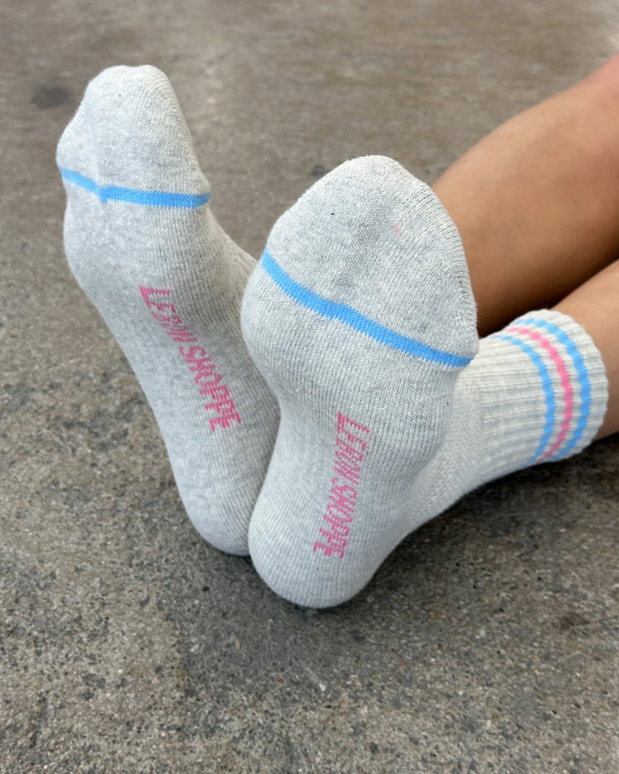 bottom view of model wearing heather grey socks with light blue and light pink stripes on the top