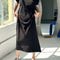 model lifting black maxi dress with slight cap sleeves and side slits