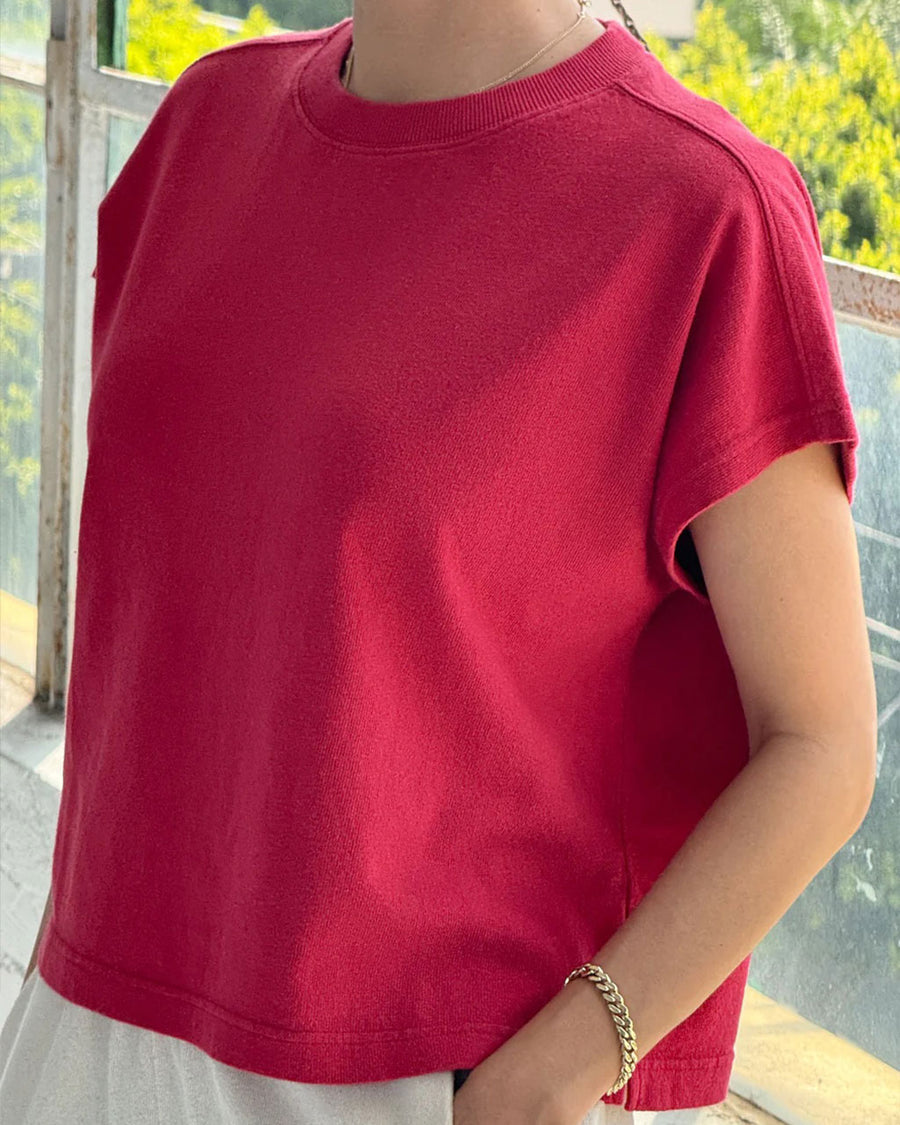 model wearing red tee with slight muscle sleeves and slight crop