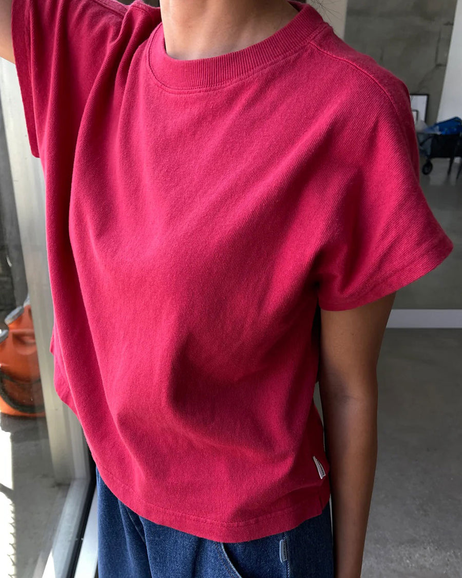 side view of model wearing red tee with slight muscle sleeves and slight crop