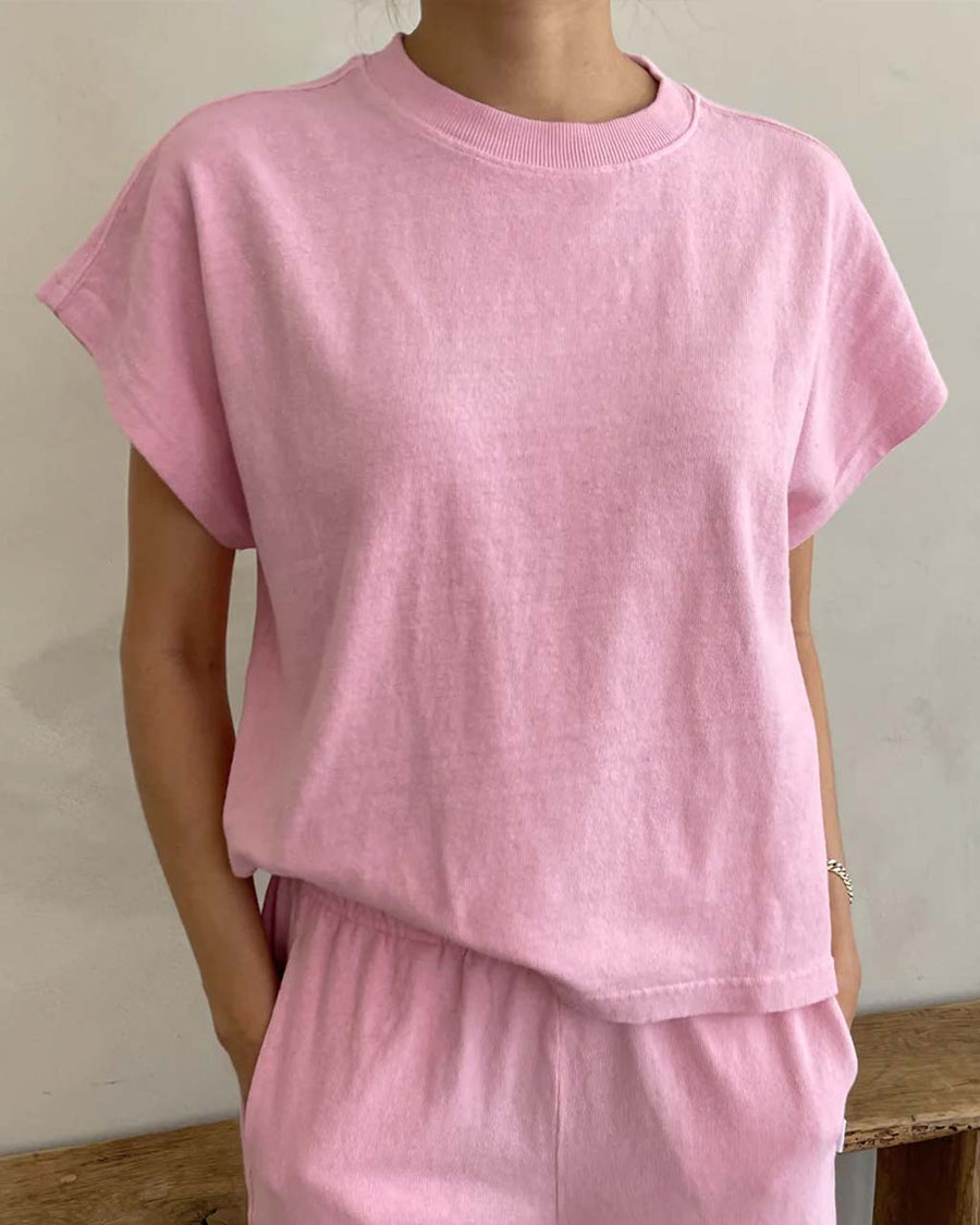 model wearing bubblegum pink tee with slight muscle sleeves and side slits