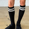 model wearing black knee high socks with two white stripes on the top