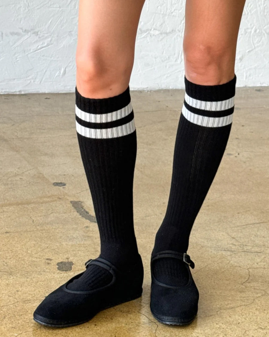 model wearing black knee high socks with two white stripes on the top