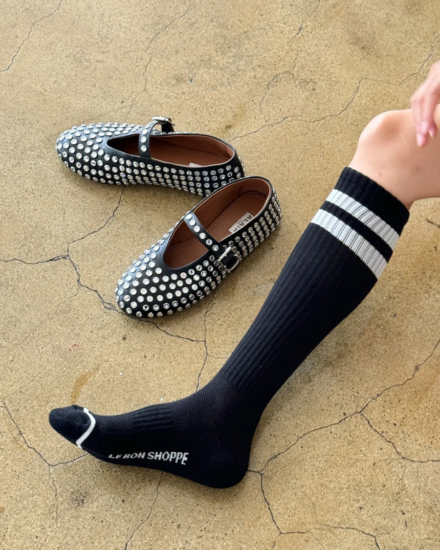 model wearing black knee high socks with two white stripes on the top