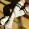 model wearing white knee high socks with two black stripes on the top