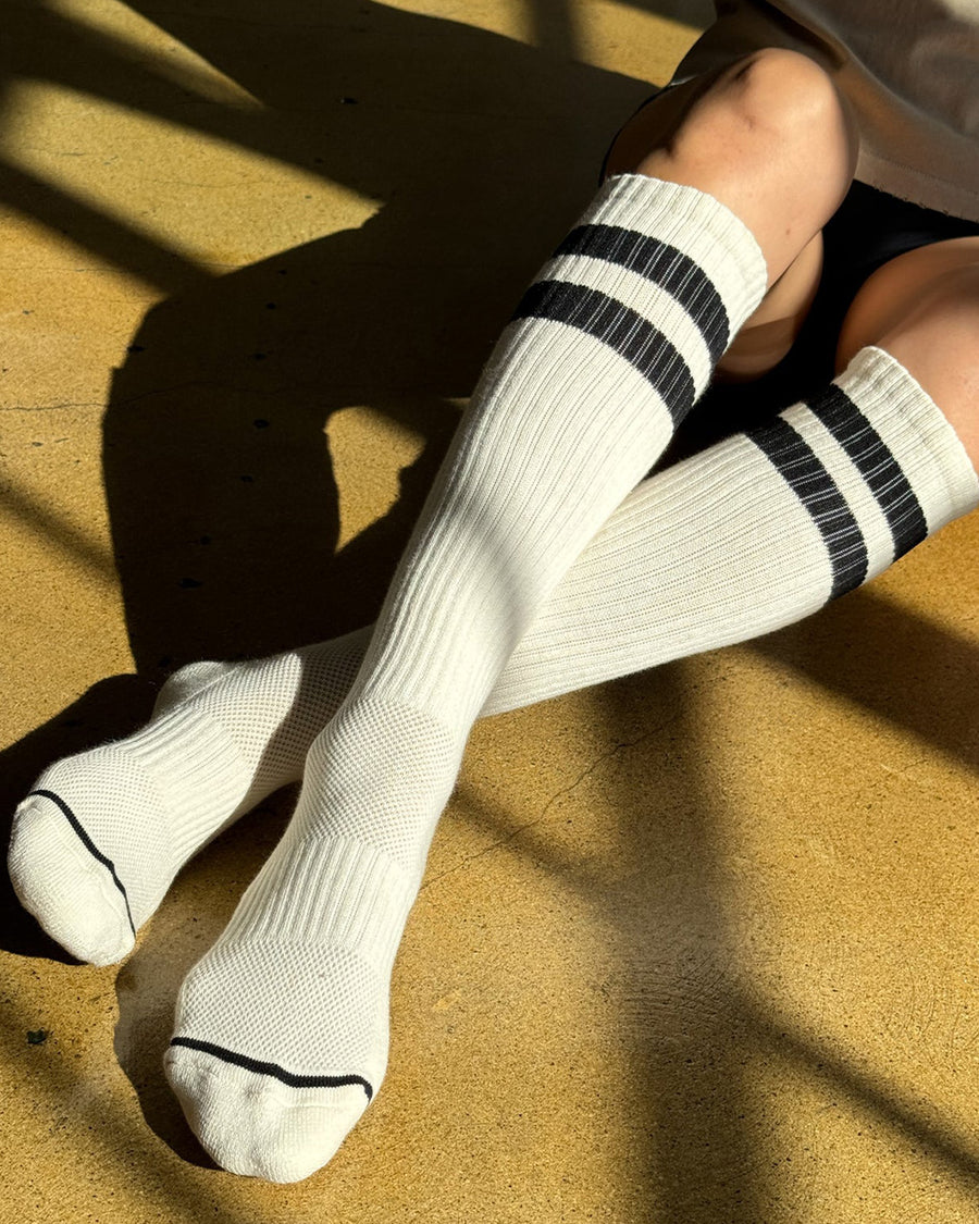 model wearing white knee high socks with two black stripes on the top