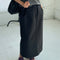 model wearing black long skirt with pockets and slit in the back