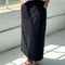 model wearing black long skirt with pockets and slit in the back