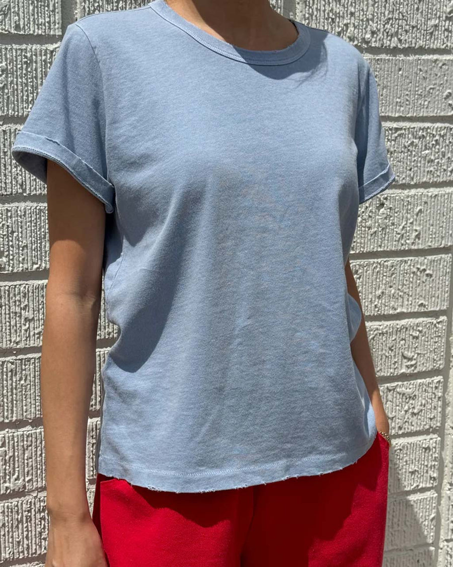 model wearing light blue organic cotton tee with a vintage look and slight distressing on the neckline and arm holes