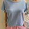 model wearing light blue organic cotton tee with a vintage look and slight distressing on the neckline and arm holes