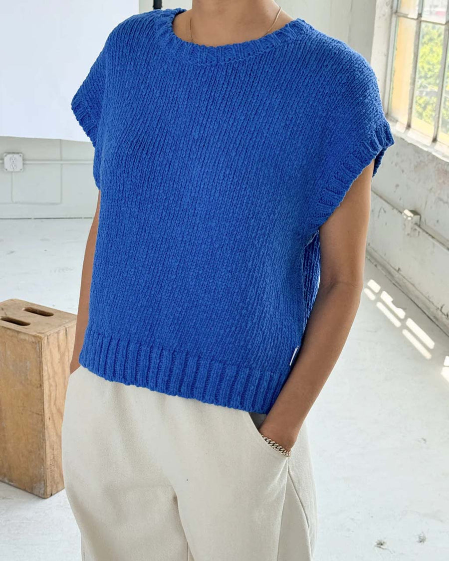 model wearing bright blue sweater top with slight cap sleeves