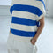 up close of model wearing bright blue and cream striped sweater top with slight cap sleeves