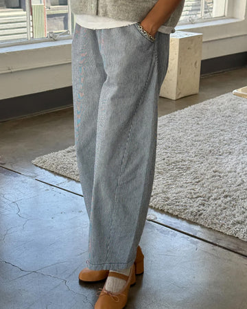 model wearing thin blue and white pinstripe heavyweight cotton pants