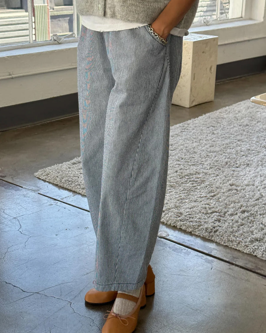 model wearing thin blue and white pinstripe heavyweight cotton pants