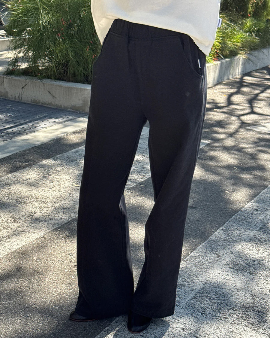 model wearing black relaxed fit cotton canvas pants with side pockets