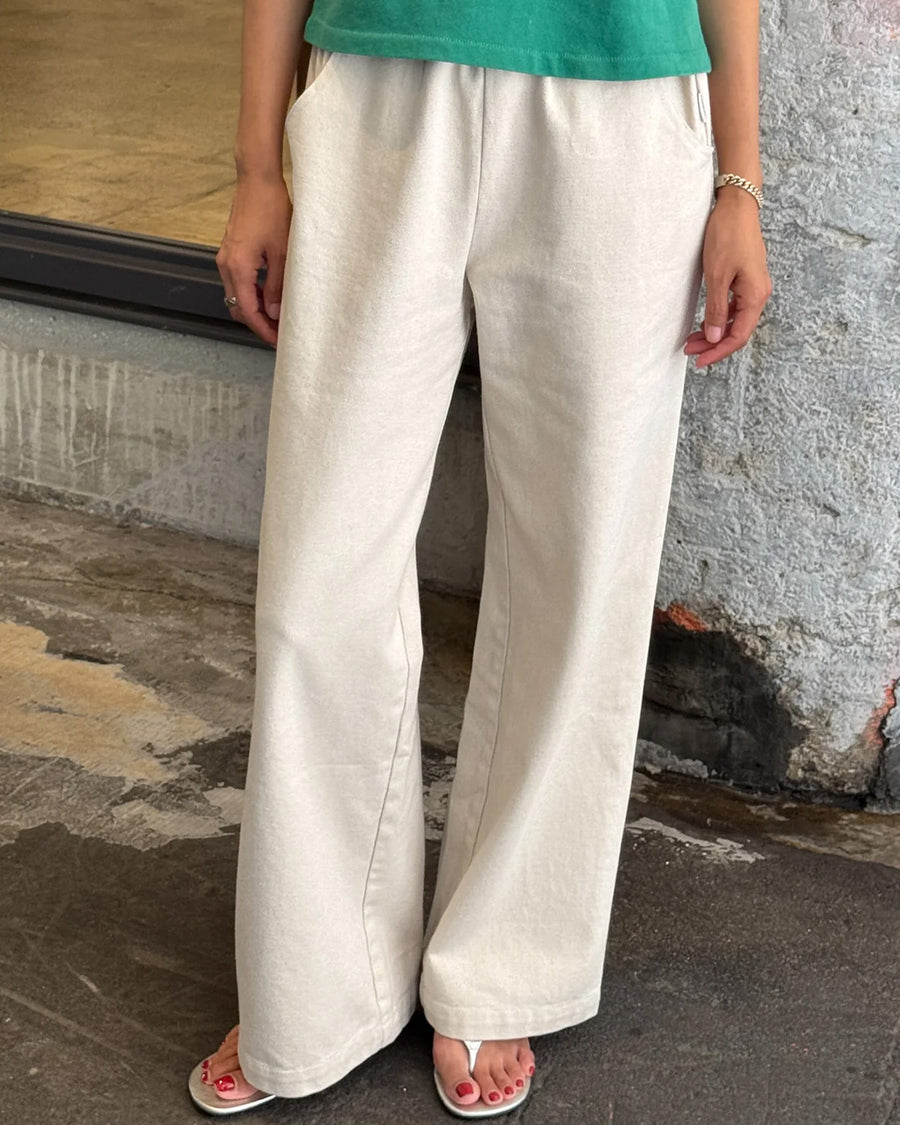 model wearing cream (naturel) relaxed fit cotton canvas pants with side pockets