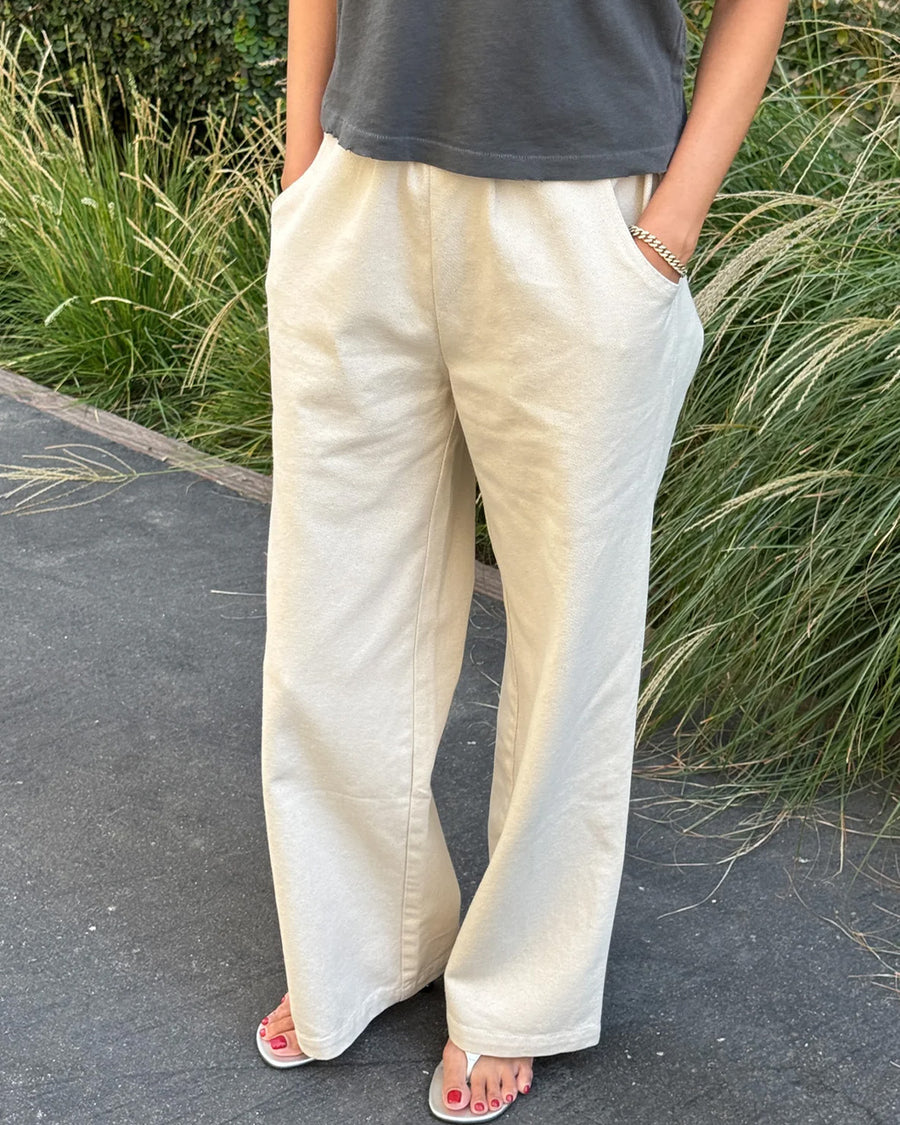 model wearing cream (naturel) relaxed fit cotton canvas pants with side pockets