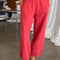 model wearing red french terry balloon pants with side pockets shown in natural light