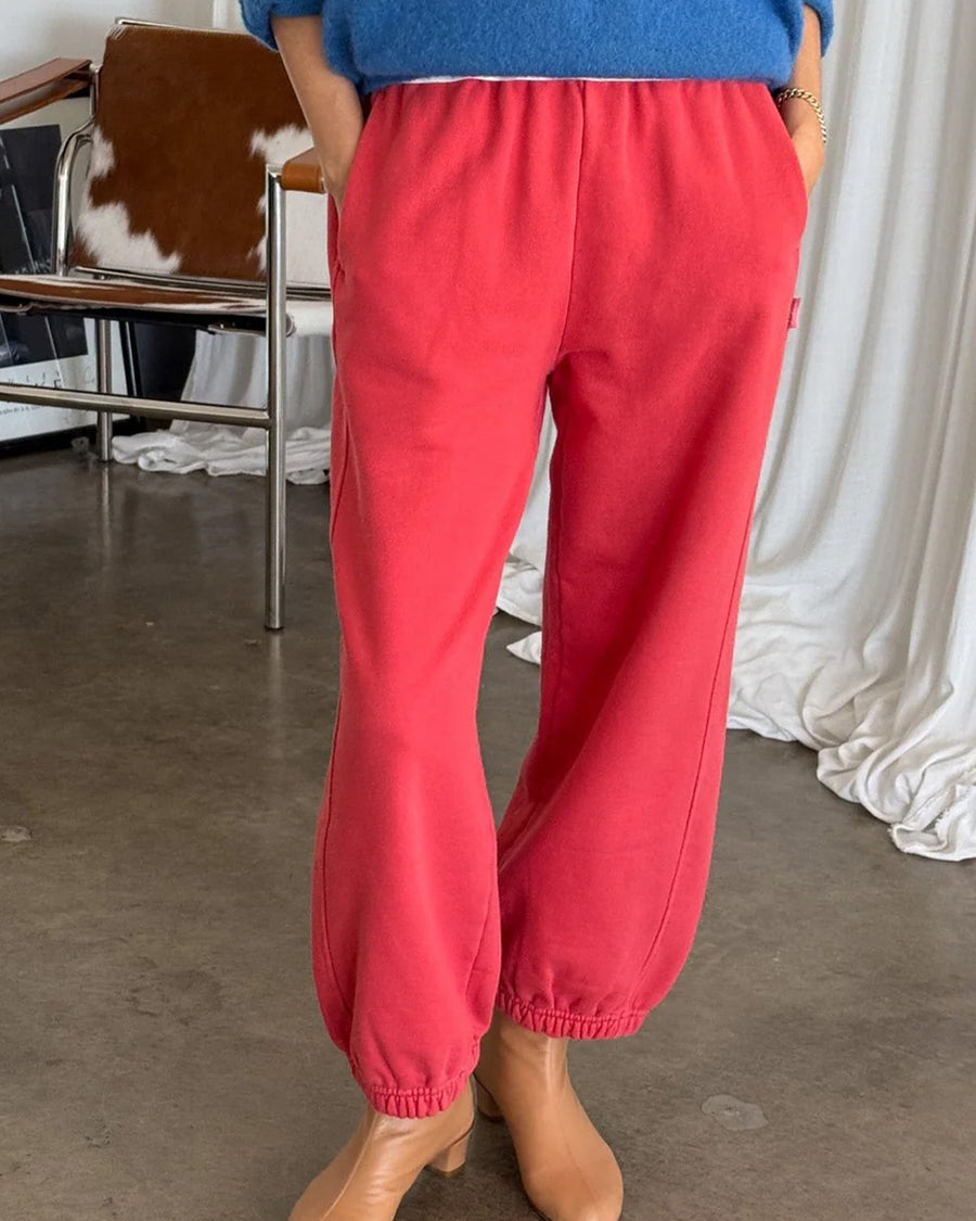 model wearing red french terry balloon pants with side pockets shown in natural light