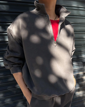 model wearing dark grey (coal) quarter zip french terry pullover sweatshirt