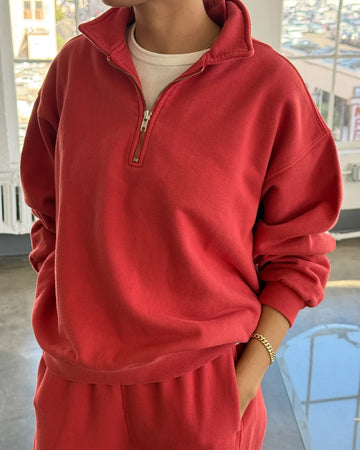 model wearing red quarter zip french terry pullover sweatshirt and matching bottoms