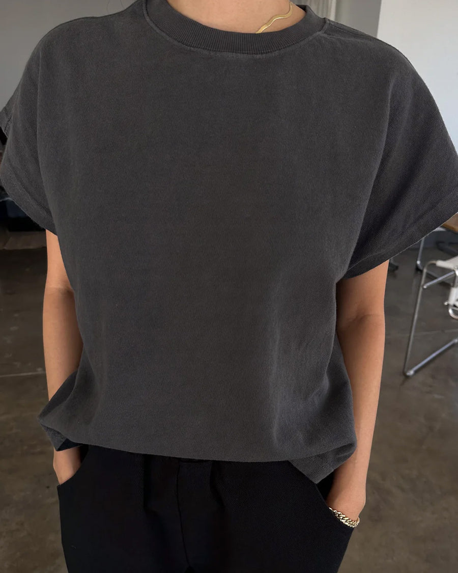 model wearing washed black tee with slight cap sleeves and shorter length