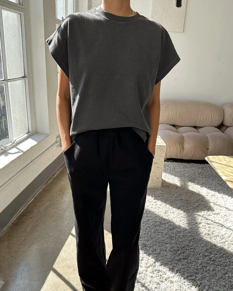 model wearing washed black tee with slight cap sleeves and shorter length