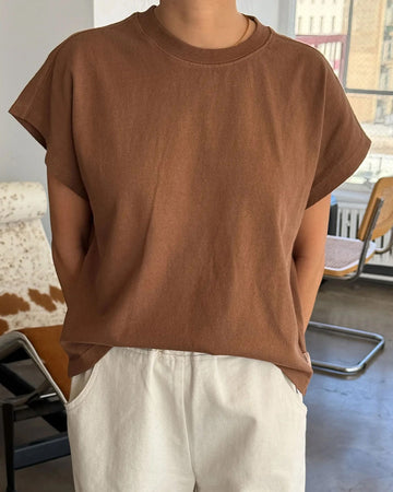 model wearing dark brown tee with slight cap sleeves and shorter length