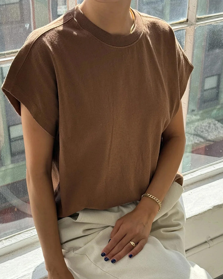 model wearing dark brown tee with slight cap sleeves and shorter length