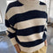 model wearing navy and white thick stripe sweater with mock neckline and yellow bottoms