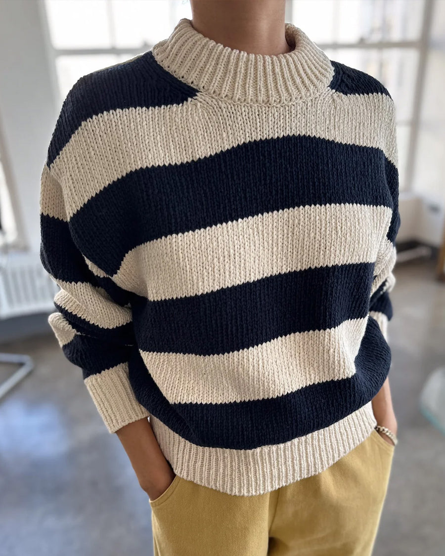 model wearing navy and white thick stripe sweater with mock neckline and yellow bottoms