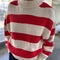 model wearing red and white thick stripe sweater with mock neckline with denim bottoms