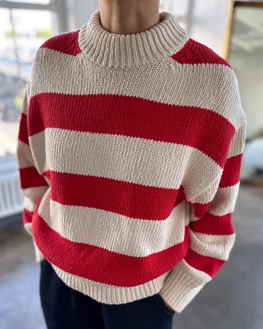 model wearing red and white thick stripe sweater with mock neckline with denim bottoms