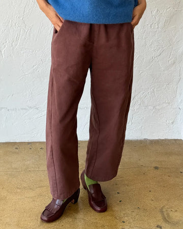 model wearing chocolate arc pants with side pockets and side insert