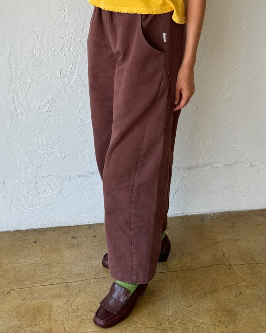 side view of model wearing chocolate arc pants with side pockets and side insert