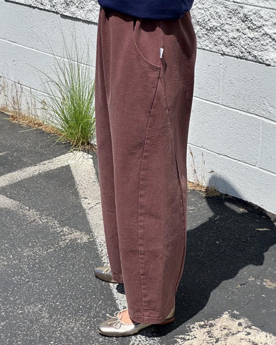 side view of model wearing chocolate arc pants with side pockets and side insert