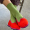 model wearing cactus green ribbed crew socks with red slip ons