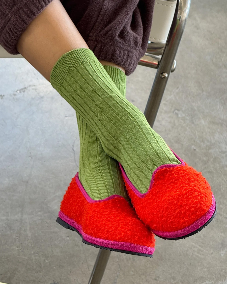 model wearing cactus green ribbed crew socks with red slip ons