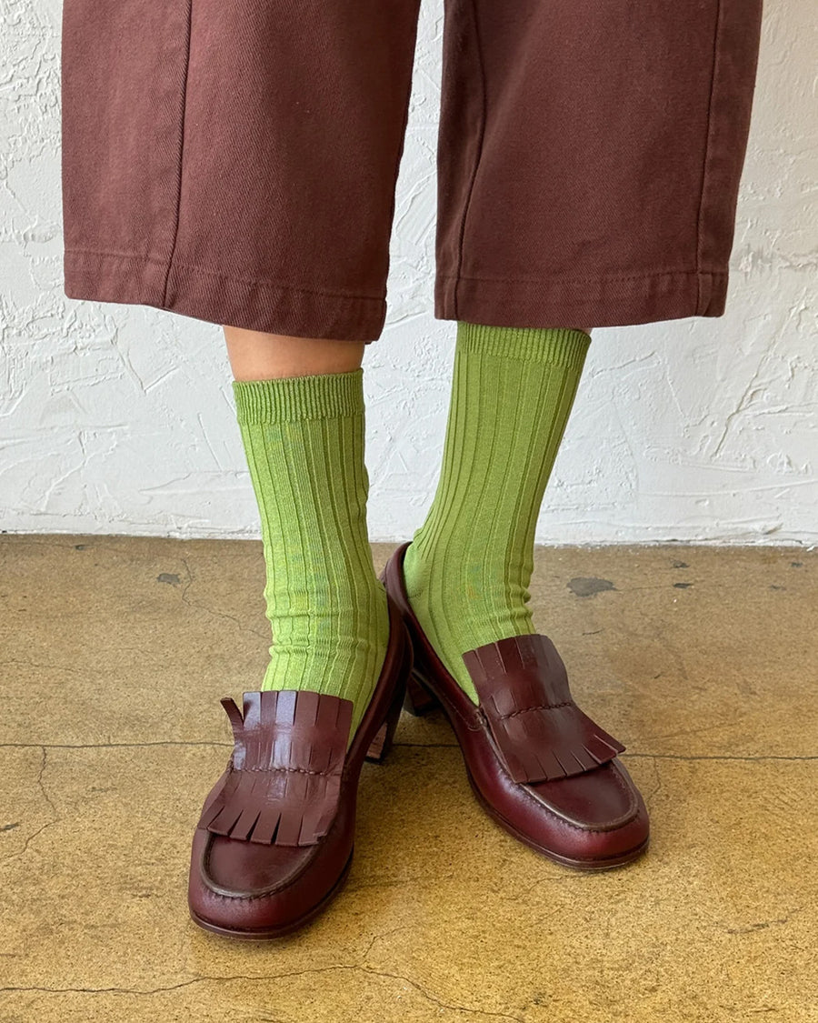 model wearing cactus green ribbed crew socks with brown shoes