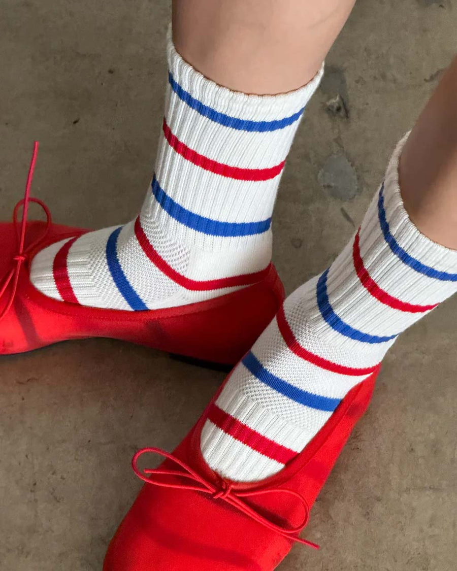 up close of model wearing white socks with blue and red alternating stripes