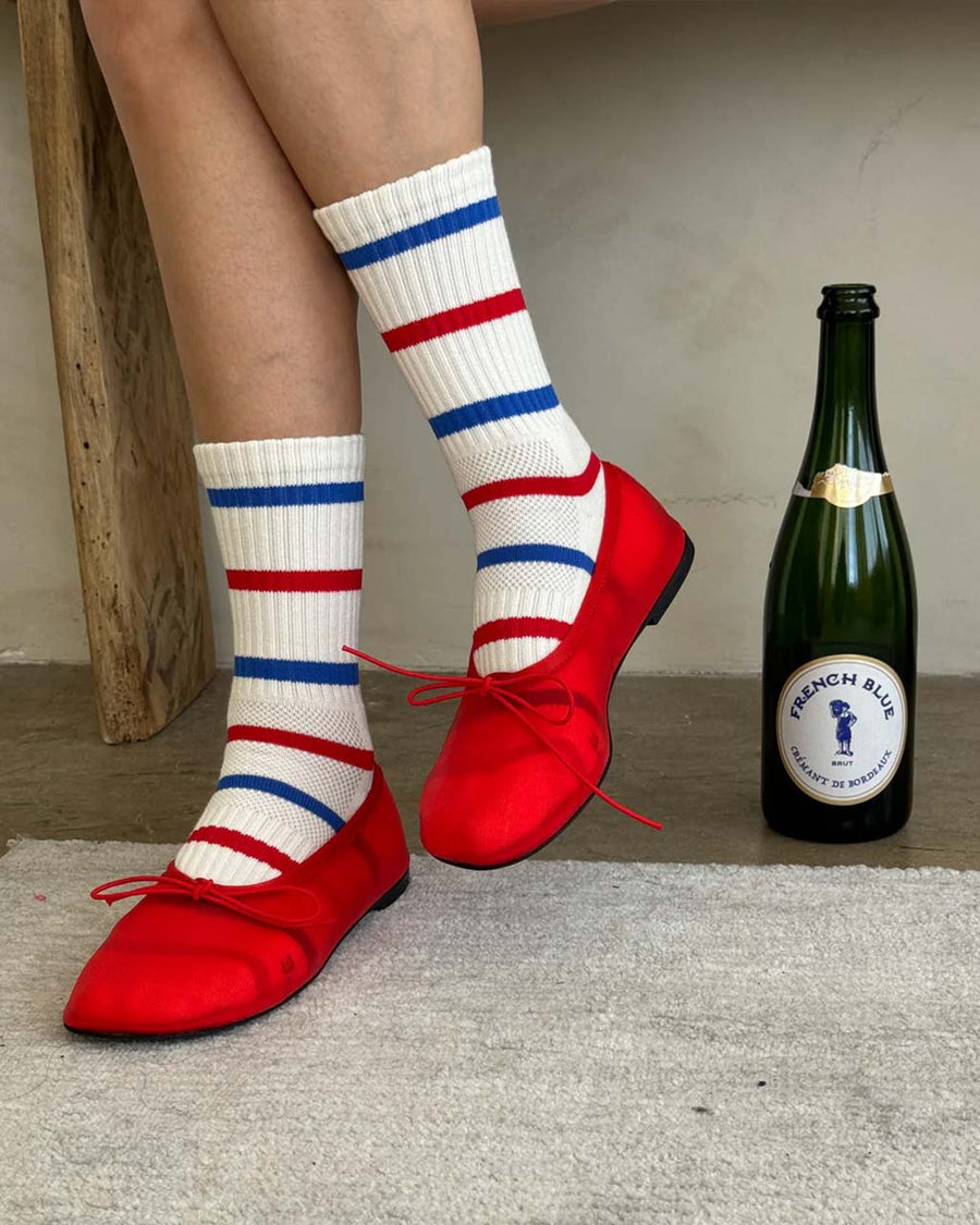 model wearing white socks with blue and red alternating stripes