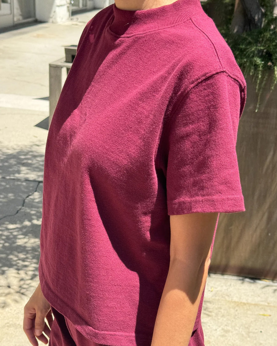 side view of model wearing cabernet colored short sleeve mock neck top