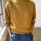 model wearing mustard yellow cotton sweater with thick banded bottom and mockneck