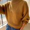 side view of model wearing mustard yellow cotton sweater with thick banded bottom and mockneck